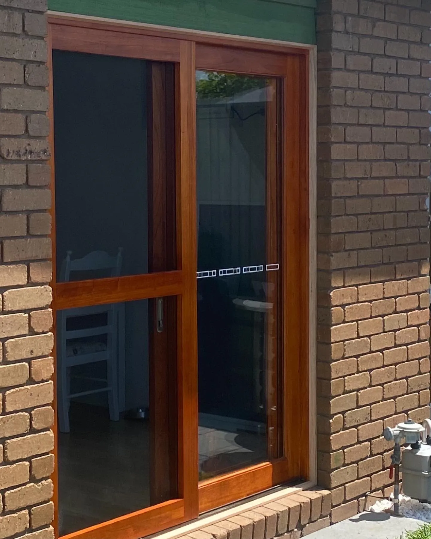 New hardwood-framed sliding door and screen fitted into a brick opening