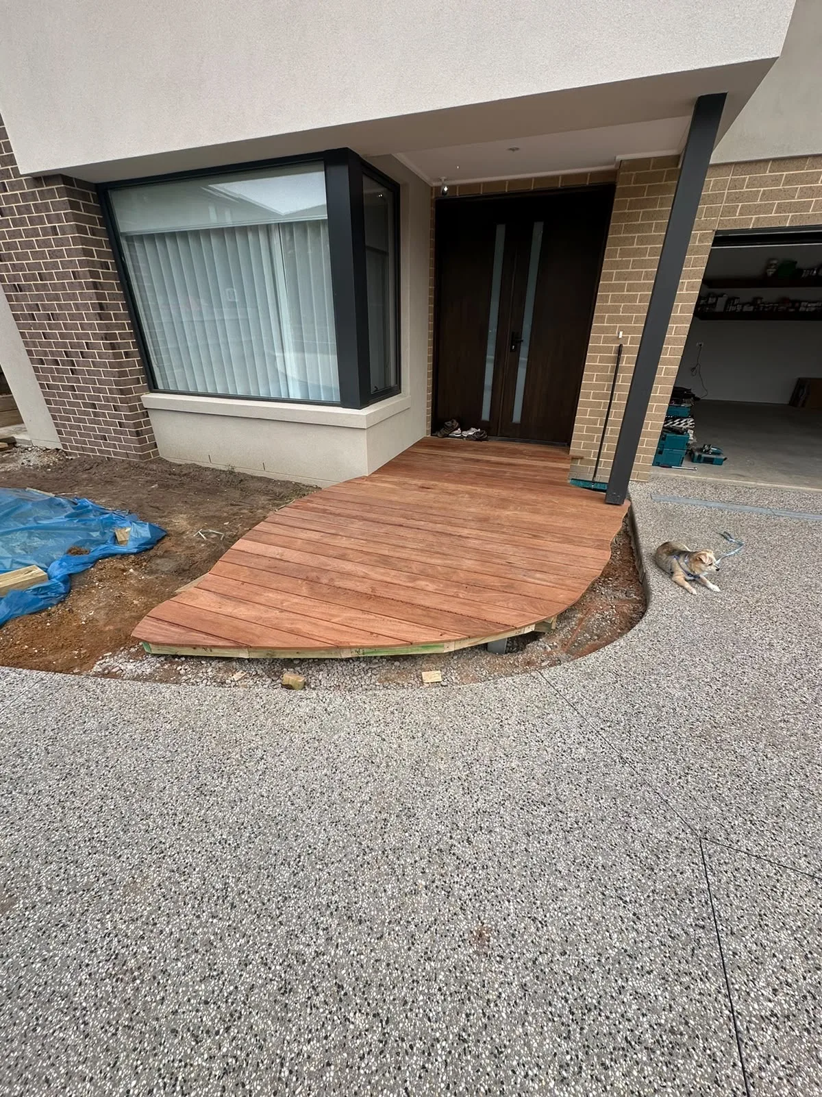 Curved merbau entry deck fitted around a bay window and front door of a new home