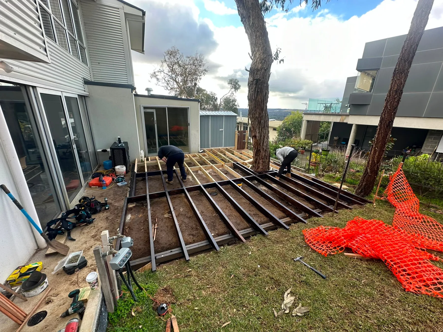 Steel and timber deck subframe set out around an established gum tree on a sloping site